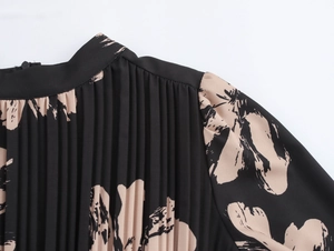 Macro shot of pleated fabric on a black and beige floral chiffon dress with fine texture