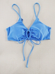 Detailed flat lay of sky blue halter bikini top featuring drawstring bow and size XXL tag