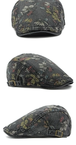 Three-way view of a dark grey washed denim flat cap featuring colorful floral patterns