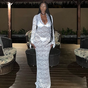 Detail of white see-through lace long dress with sheer floral patterns and flare sleeves