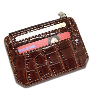 Detail of brown crocodile pattern leather wallet with multiple card slots and zipper closure