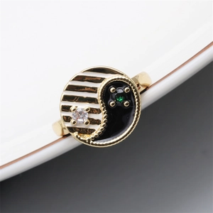 Detailed close-up of gold Yin Yang ring with black white enamel and inlaid gemstones