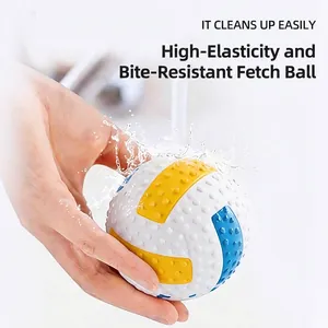 Durable rubber pet training ball with non-slip texture being rinsed under water