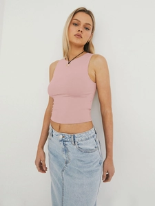 Close-up of a pink Y2K style cropped tank top paired with a denim skirt and simple necklace