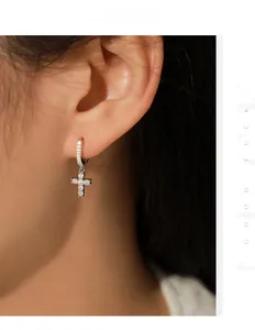 Detailed view of s925 silver cross drop earrings with pavé moissanite on model