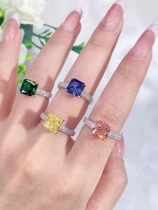 Detailed view of four colorful square-cut gemstone rings with side-stone micro-paving