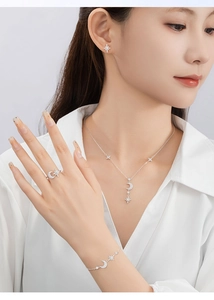 Detail of 925 silver star and moon jewelry set with zircons on model neck and wrist