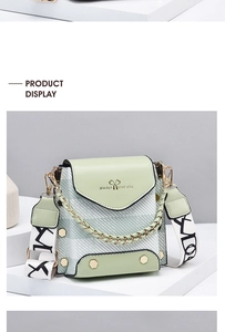 Detail view of mint green mini crossbody bag with striped pattern and chain strap