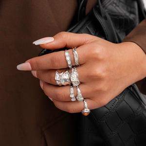 Detail of silver textured rings with liquid metal style and gemstone inlays