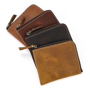 Detailed view of four vintage crazy horse leather wallets with L-shaped zippers in earth tones