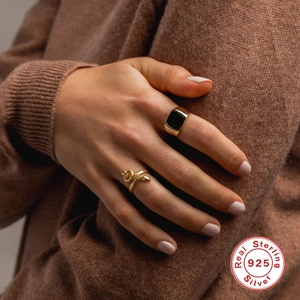 Detail of 925 sterling silver gold snake ring and black stone signet ring on model