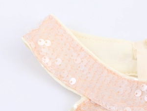 Detail of pink sequins on cream mesh fabric showing exquisite halter dress craftsmanship