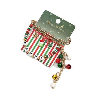 Détails d'une broche de Noël avec perles Happy, clochettes et breloques festives sur fond blanc