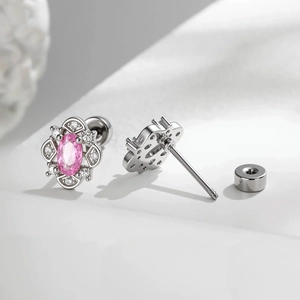 Elegant geometric oval pink zircon stud earrings with small clear stones on a white surface