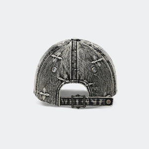 Détail de la casquette en denim délavé avec boucle réglable et décorations d'étoiles gothiques