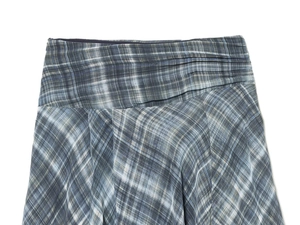 Détail de la taille plissée sur une jupe en tissu à carreaux bleu et gris chiné