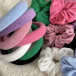 Colorful sponge towel fabric headband and scrunchie set on beige knitted background