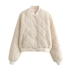 Détail de veste matelassée blanc cassé avec motifs losanges et bords-côtes