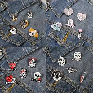 Gothic enamel pin set with black cat and skull designs on denim jacket