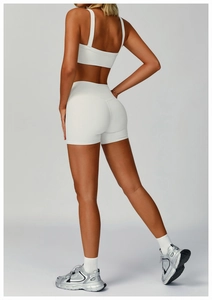Detail view of white ribbed yoga set featuring broad straps vest and high waist shorts