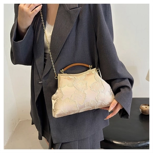 Close-up of beige satin cheongsam handbag with floral embroidery and wooden handle