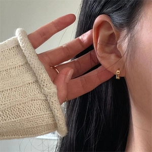 Minimalist 925 sterling silver gold heart hoop earrings worn on a female model's ear