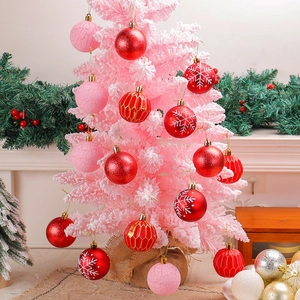 Pink and red Christmas ball ornaments with snowflake patterns on a Christmas tree