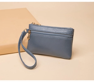 Blue lychee pattern coin purse with double gold zippers and a wrist strap detail