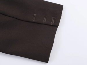 Detail of dark brown blazer cuff showing three buttonholes and fine twill fabric texture