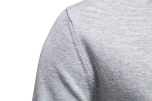 Detailed close-up of shoulder seam stitching on a grey knitted men cardigan sweater