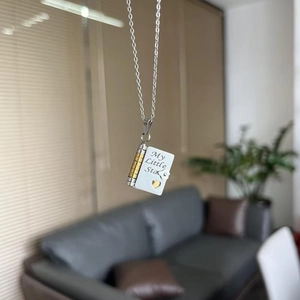 Close-up of engraved book pendant with golden heart and My Little Star text