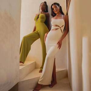 Sexy backless halter jumpsuit and white hollow-out maxi dress on beige stairs