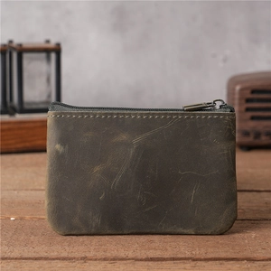 Vue rapprochée du porte-monnaie en cuir vintage avec fermeture éclair en bronze sur bois