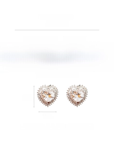Close-up of heart-shaped zircon stud earrings with silver needles and copper base