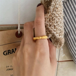 Detail of 925 sterling silver knotted ring in gold finish with rope texture