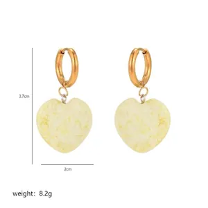 Detail showing heart-shaped earrings dimensions with golden ring and yellow stone inlay