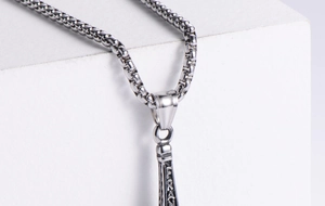 Macro detail of Eiffel Tower stainless steel pendant showing France engraving and box chain
