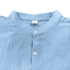 Detail of the stand collar and button on this blue 100% cotton casual slim shirt for men