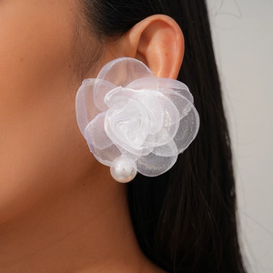 Gros plan détaillé d'une boucle d'oreille fleur en tissu blanc avec perle sur mannequin