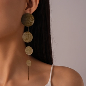 Macro shot of gold geometric layered circular drop earrings with textured spiral finish