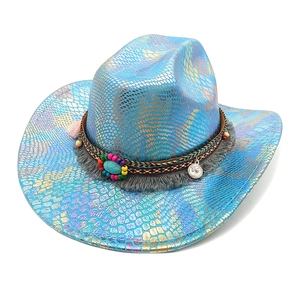 Détail du chapeau de cowboy en serpent irisé bleu avec pompons bohèmes et turquoise
