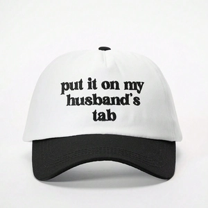 Détail de la broderie du texte « put it on my husband's tab » sur une casquette noir et blanc