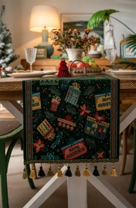 Detail of green Christmas table runner with tassels featuring Merry Christmas jacquard