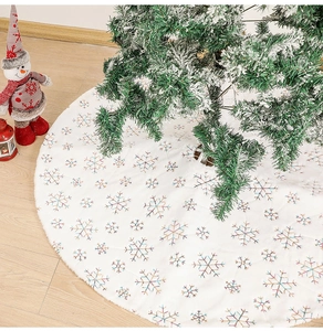 Detailed view of plush white Christmas tree skirt featuring colorful snowflake embroidery