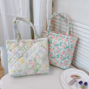 Detail of floral quilted cotton tote bag featuring diamond stitching and brand tag
