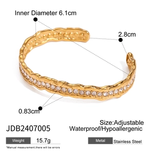 Goldenes Edelstahl-Armreif mit Wellendesign, weißen Steinen und gehämmerter Textur