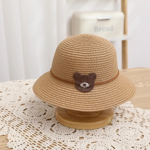 Close-up of kids straw sun hat with bear patch and brown leather band detail