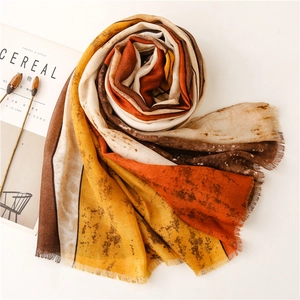 Detailed macro view of ink-wash style summer scarf with fringed edges and warm tones
