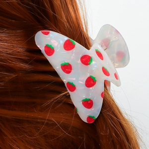 Chic acetate hair claw clip with strawberry print worn on long brunette hair