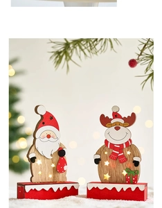 Close-up of wooden Christmas tabletop ornament with warm LED lights and deer pattern
